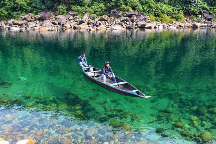 Crystal clear glass waters of Umngot River with tourist boats in Dawki, Meghalaya